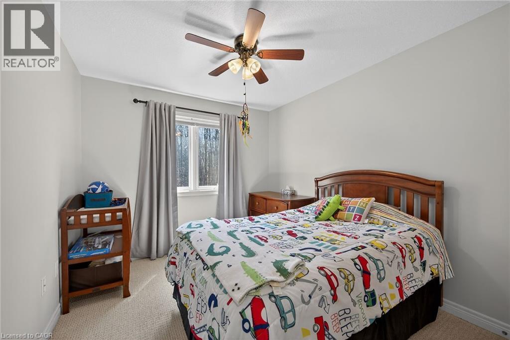 Carpeted room with light gray walls and a single window featuring a dark rod and light gray curtains - 149 Kinsman Drive, Binbrook, ON