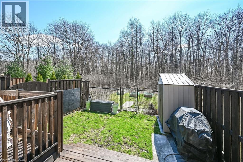 Backyard featuring a wooden privacy fence, a storage shed, and a grassy area backing onto a treed expanse - 149 Kinsman Drive, Binbrook, ON