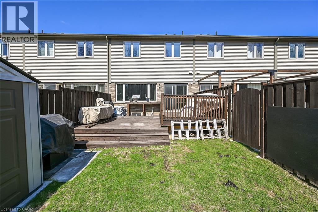 Rear exterior featuring a multi-tiered wood deck, privacy fencing, and a grassy yard - 149 Kinsman Drive, Binbrook, ON