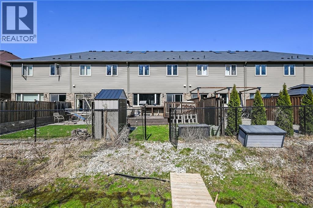 Rear exterior showcasing a multi-level deck, stone patio, and fenced yard - 149 Kinsman Drive, Binbrook, ON