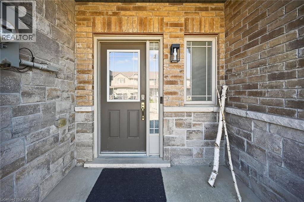 Exterior entry featuring a paneled door with a glass insert, sidelight, and transom window - 149 Kinsman Drive, Binbrook, ON