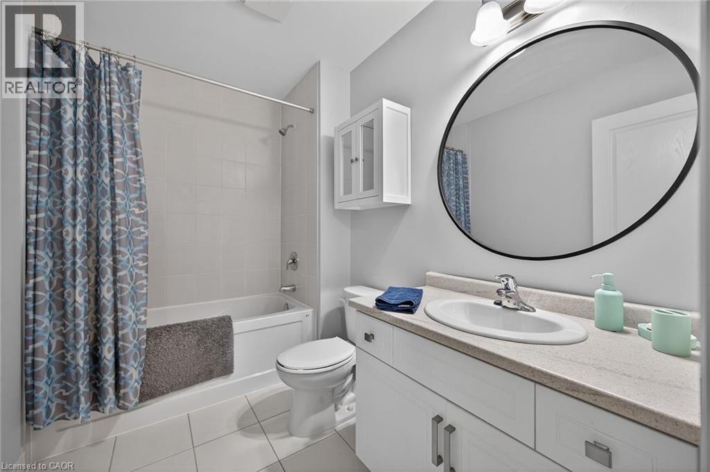 Full bathroom featuring a single vanity with an oval undermount sink, a countertop with a light stone-finish, and white cabinetry - 149 Kinsman Drive, Binbrook, ON