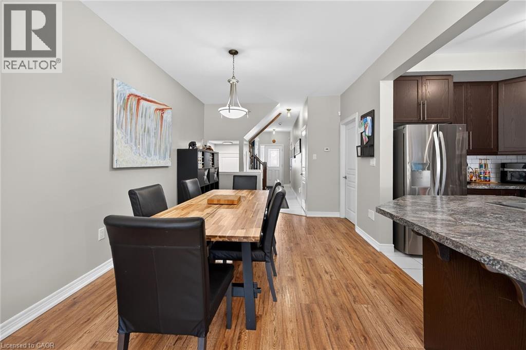 Dining area featuring wood-finish flooring and a contemporary pendant light fixture - 149 Kinsman Drive, Binbrook, ON
