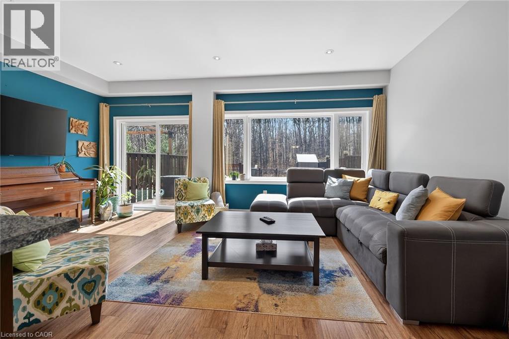 Open-concept living space featuring wood-finish flooring, recessed lighting, and a sliding glass door providing outdoor access - 149 Kinsman Drive, Binbrook, ON