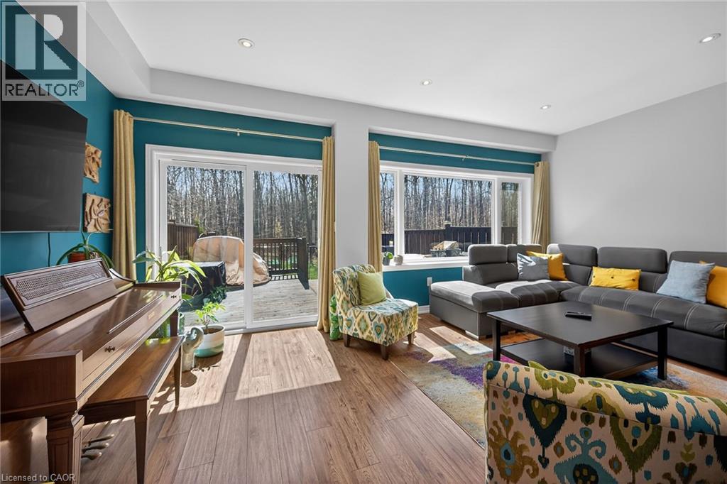Living area featuring wood-finish flooring, recessed lighting, and a large sliding glass door opening onto an outdoor deck - 149 Kinsman Drive, Binbrook, ON