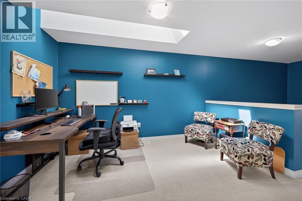 Spacious room featuring vibrant blue walls, light-colored carpet flooring, a skylight, and recessed lighting - 149 Kinsman Drive, Binbrook, ON