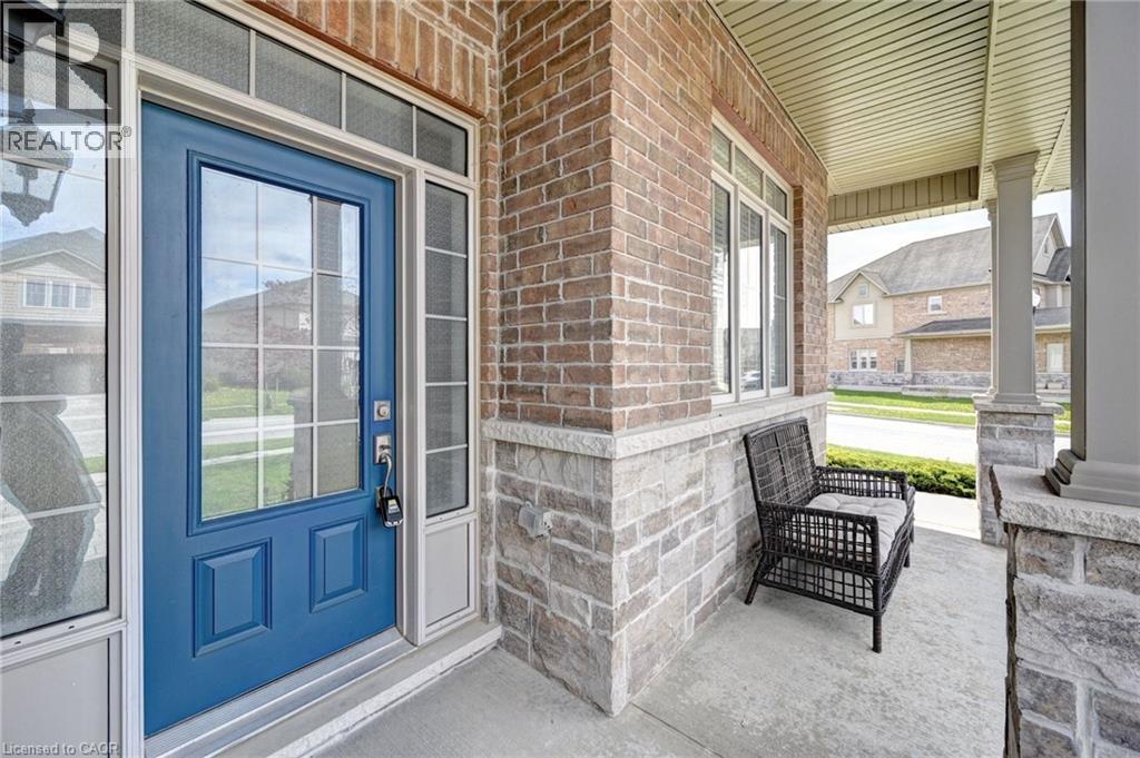 Inviting front entry featuring a bold blue door with glass lites, sidelights, and a transom window - 219 Falconridge Drive, Kitchener, ON - Outdoor With Exterior