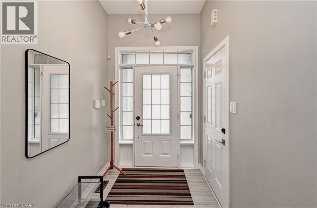 Entryway featuring a transom window and sidelights, a modern multi-bulb chandelier, and wood-finish flooring - 219 Falconridge Drive, Kitchener, ON - Indoor Photo Showing Other Room