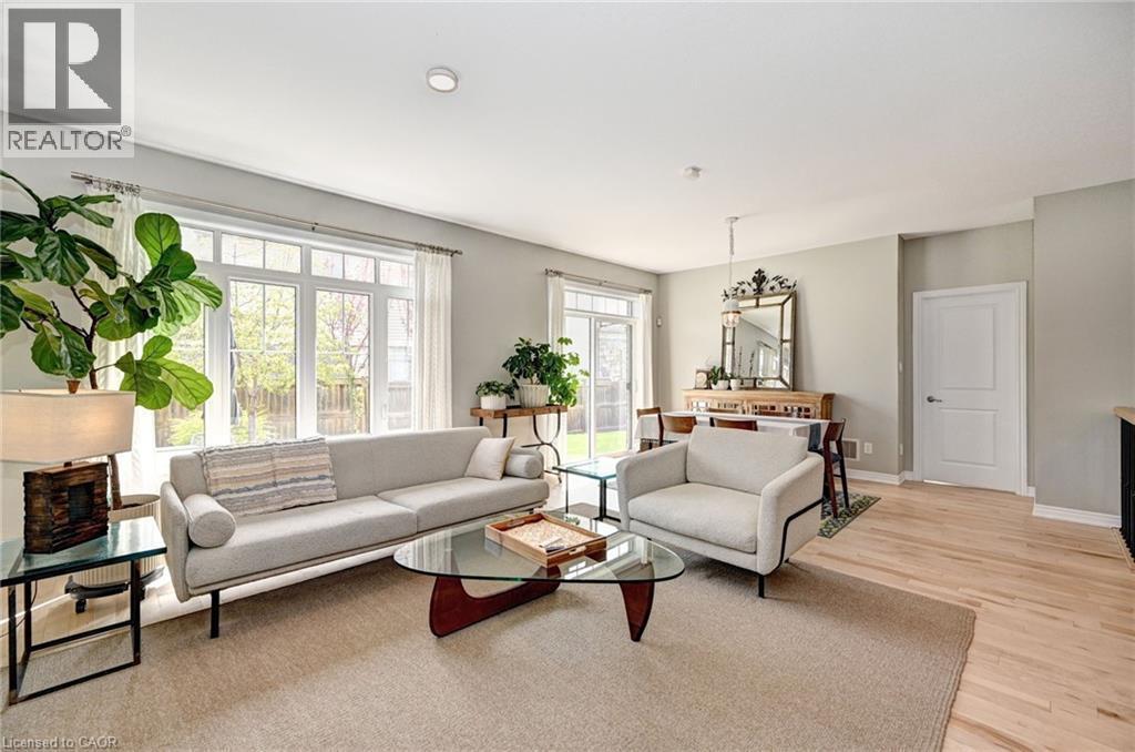 Open-concept living space with extensive natural light from large windows and a sliding glass door - 219 Falconridge Drive, Kitchener, ON - Indoor Photo Showing Living Room