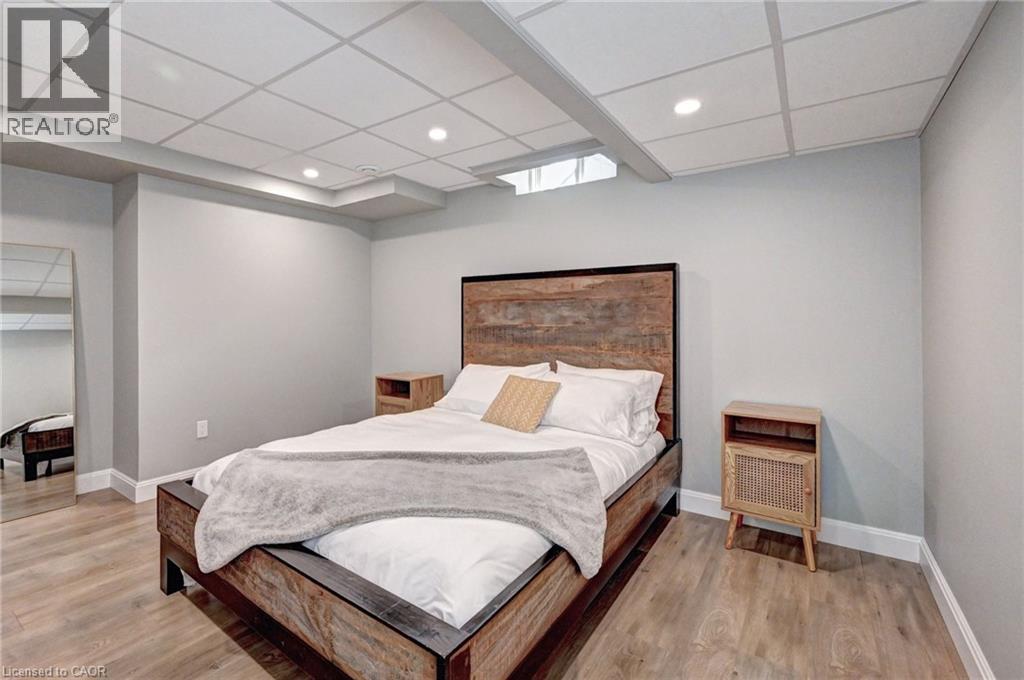 Bedroom featuring wood-finish flooring, light gray walls, white trim, and a grid drop ceiling with recessed lighting - 219 Falconridge Drive, Kitchener, ON - Indoor Photo Showing Bedroom