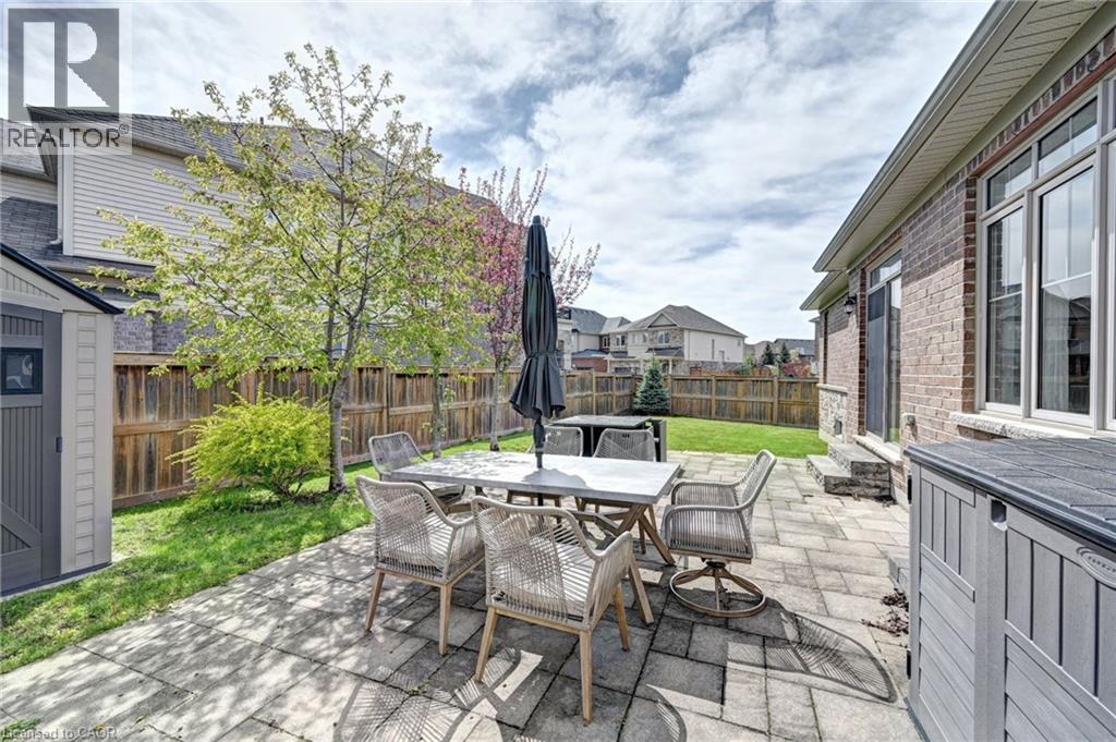 Spacious backyard featuring a paver patio, manicured lawn, and a privacy fence - 219 Falconridge Drive, Kitchener, ON - Outdoor With Deck Patio Veranda With Exterior