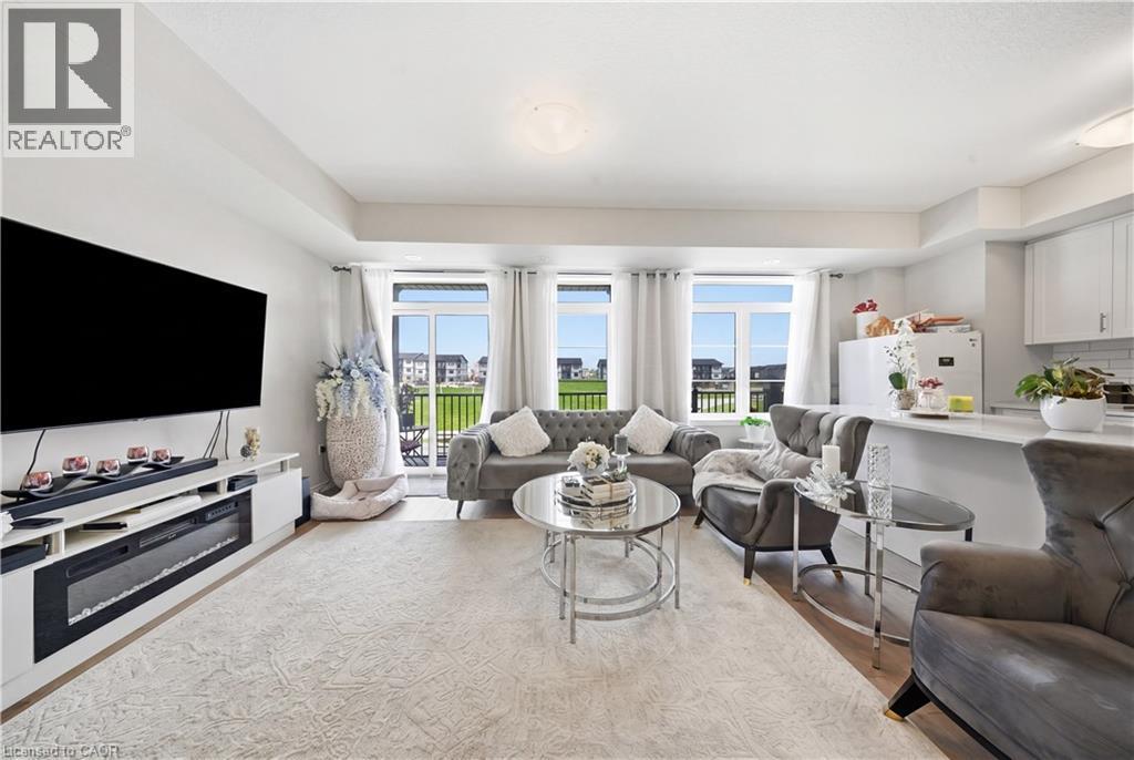 Open-concept living area, multiple large windows, and direct access to an outdoor space - 176 Wheat Lane, Kitchener, ON - Indoor Photo Showing Living Room