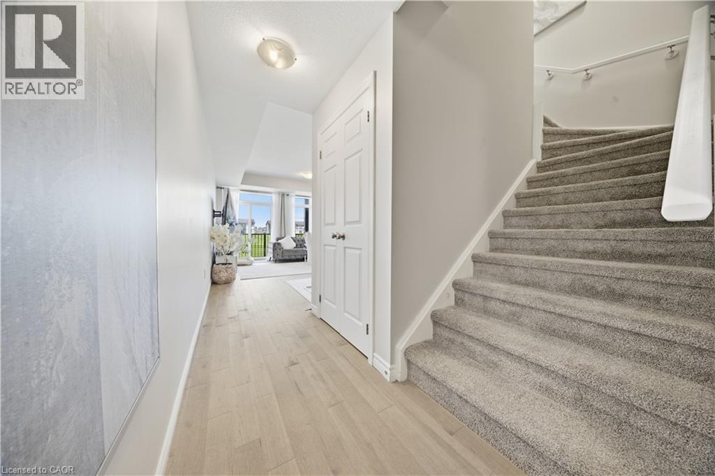 Light wood-finish flooring extending from the entryway - 176 Wheat Lane, Kitchener, ON - Indoor Photo Showing Other Room
