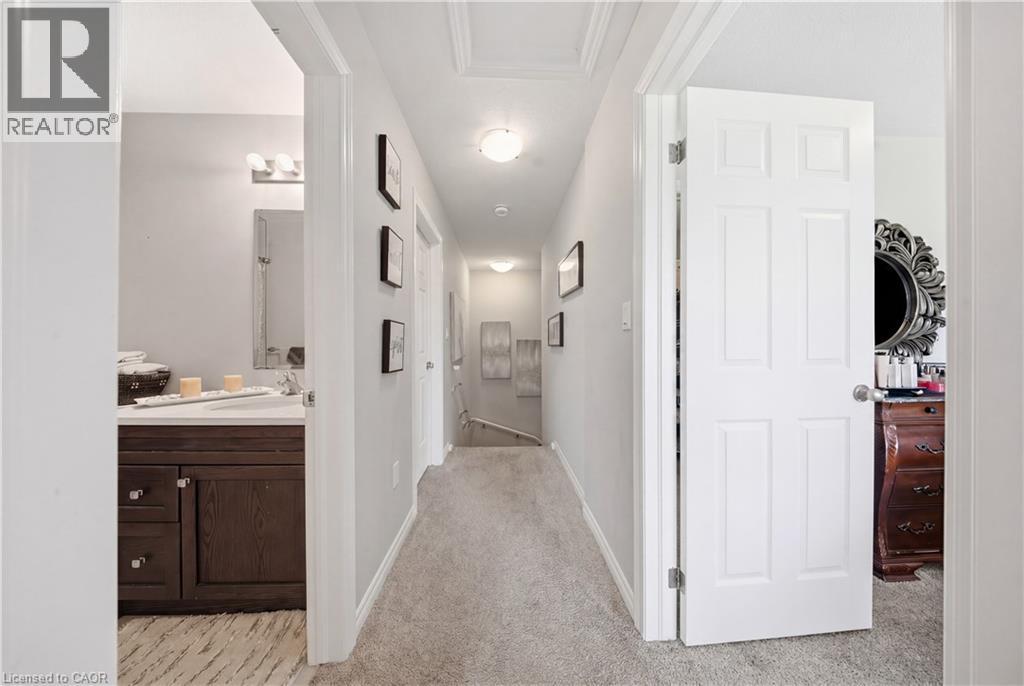 Carpeted hallway featuring a recessed ceiling light fixture, white paneled doors, and light gray walls - 176 Wheat Lane, Kitchener, ON - Indoor Photo Showing Other Room