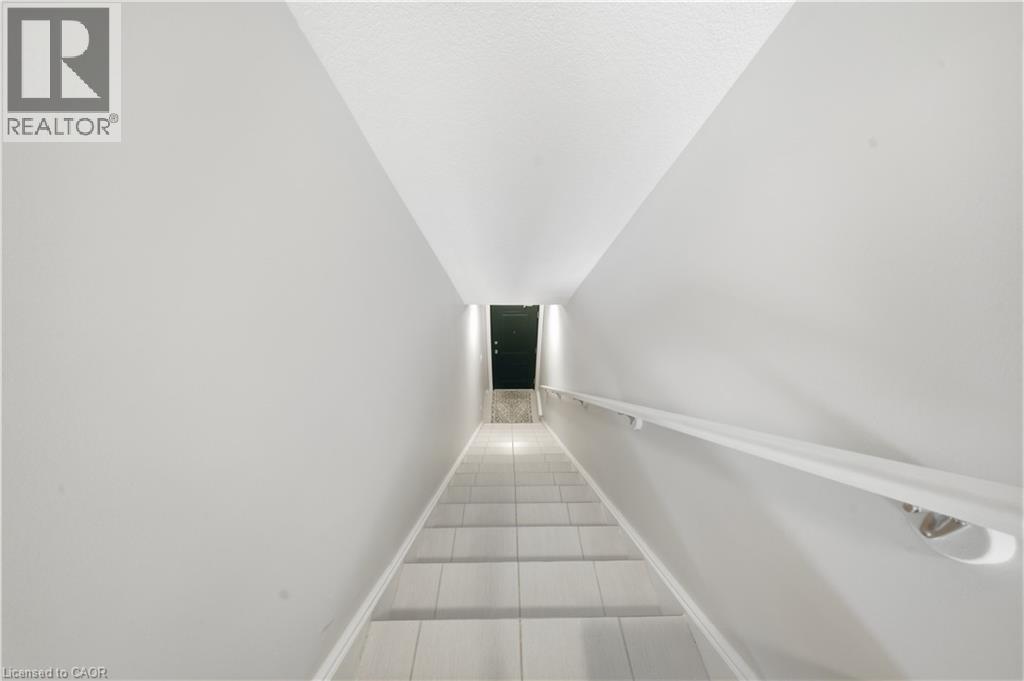 Staircase with light-toned steps and a white wall-mounted handrail - 176 Wheat Lane, Kitchener, ON - Indoor Photo Showing Other Room