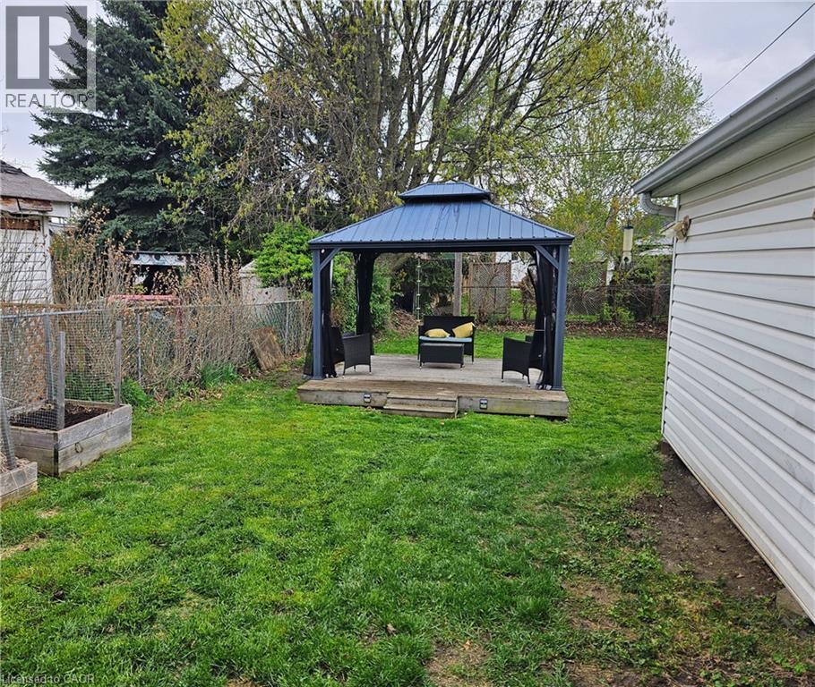Expansive backyard featuring a central wooden deck with a built-in gazebo - 75 Barons Avenue S, Hamilton, ON - Outdoor With Deck Patio Veranda