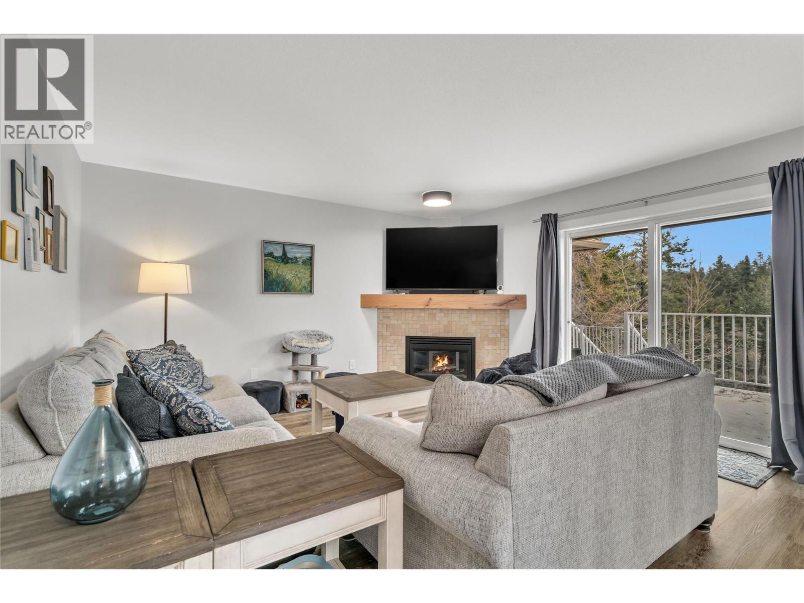 Cozy living room or make this your dining room - 3819 Glen Canyon Drive, West Kelowna, BC - Indoor Photo Showing Living Room With Fireplace