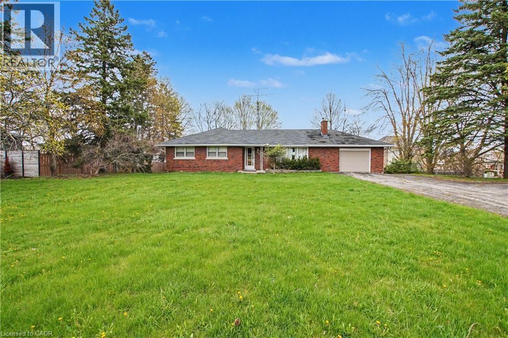 Expansive front lawn with mature trees and a long gravel driveway - 355 Guelph Avenue, Cambridge, ON