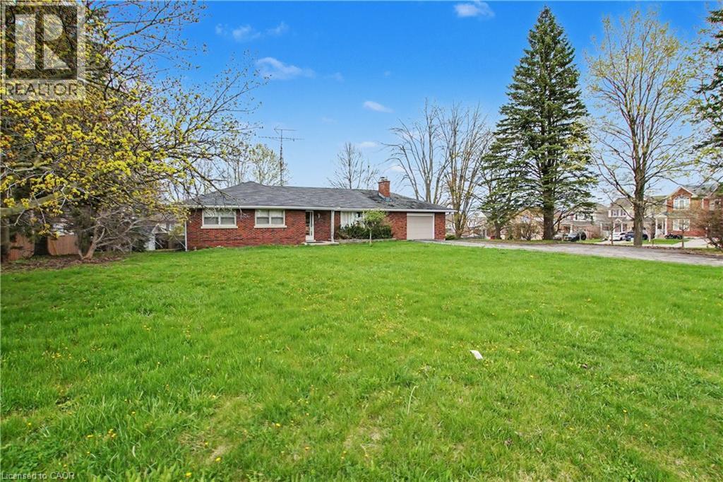 Expansive front lawn with mature trees and a brick single-story residence - 355 Guelph Avenue, Cambridge, ON