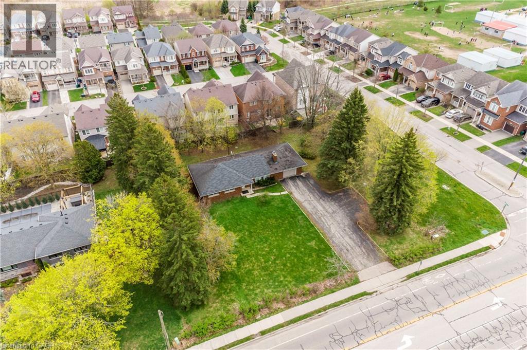 Single-story brick exterior residence featuring an attached garage, an asphalt driveway, and a shingled roof - 355 Guelph Avenue, Cambridge, ON