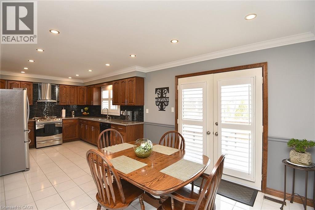 Kitchen featuring wood cabinetry, stainless steel appliances, granite countertops, and dark tile backsplash - 36 Tommar Place, Hamilton, ON - Indoor Photo Showing Dining Room