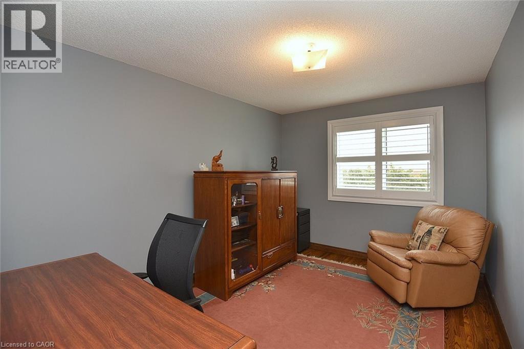 Room with wood-finish flooring, light grey walls, and a white window frame featuring white louvered shutters - 36 Tommar Place, Hamilton, ON - Indoor Photo Showing Office