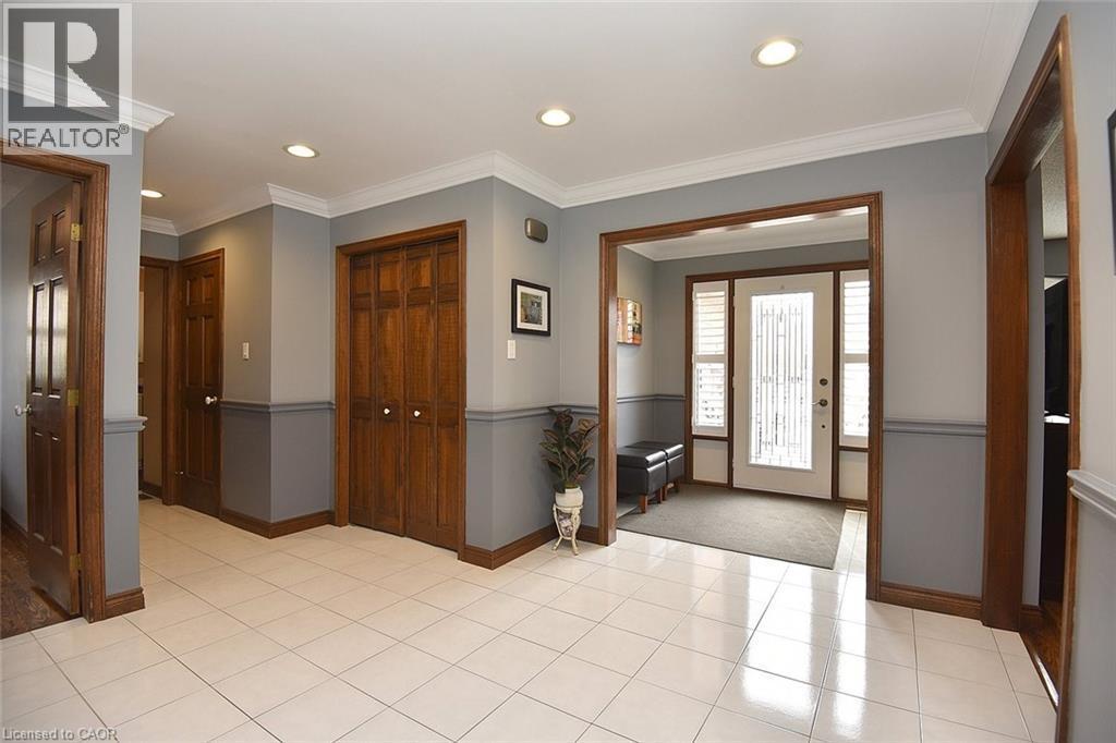 Foyer featuring ceramic tile flooring, recessed lighting, crown molding, two-tone wall treatment, and a paneled entry door with sidelights - 36 Tommar Place, Hamilton, ON - Indoor Photo Showing Other Room