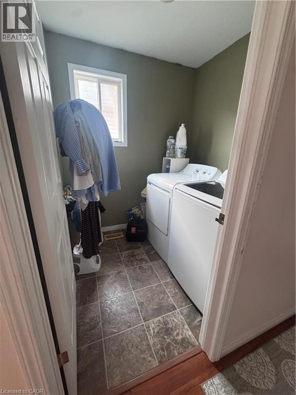Dedicated laundry area featuring a window, tile-look flooring, and a pair of white appliances - 452 Beaumont Crescent, Kitchener, ON - Indoor Photo Showing Laundry Room