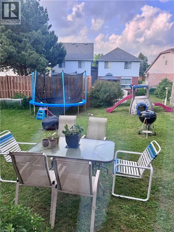 Expansive fenced yard featuring a manicured lawn and mature trees - 452 Beaumont Crescent, Kitchener, ON - Outdoor With Deck Patio Veranda