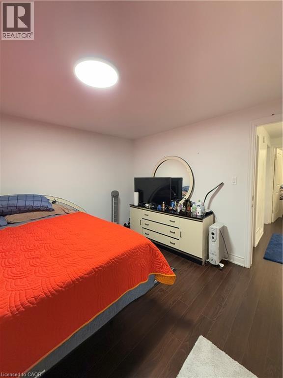 Dark wood-finish flooring with white baseboards and a ceiling-mounted light fixture - 181 Thaler Avenue, Kitchener, ON
