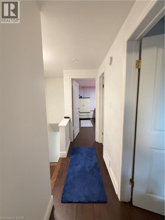 Hallway with wood-finish flooring, white walls, and recessed lighting - 181 Thaler Avenue, Kitchener, ON