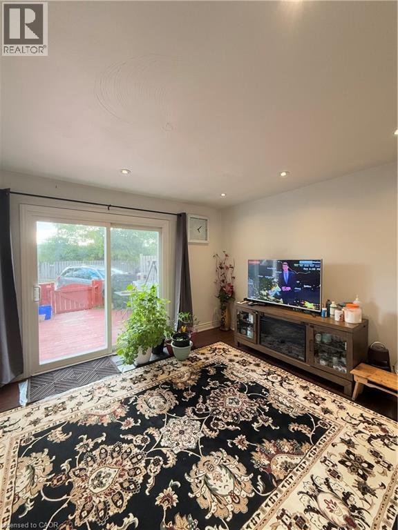 Living area featuring wood-finish flooring, recessed ceiling lighting, and a sliding glass door providing access to an outdoor deck - 181 Thaler Avenue, Kitchener, ON