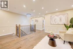 Upper landing featuring wood-finish flooring, recessed lighting, and wainscoting -