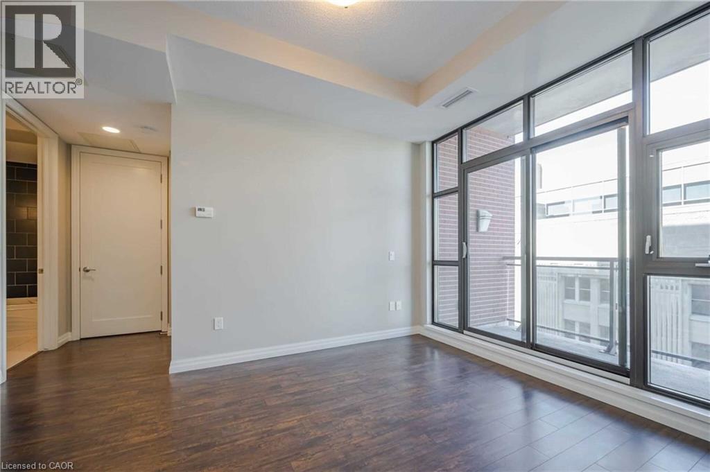 Expansive window wall with dark framing and a glass balcony railing - 112 King Street E Unit# 907, Hamilton, ON