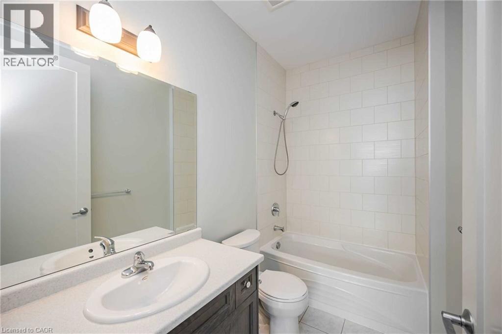 Bathroom featuring a single vanity with a white countertop, an oval undermount sink, and a chrome faucet - 112 King Street E Unit# 907, Hamilton, ON