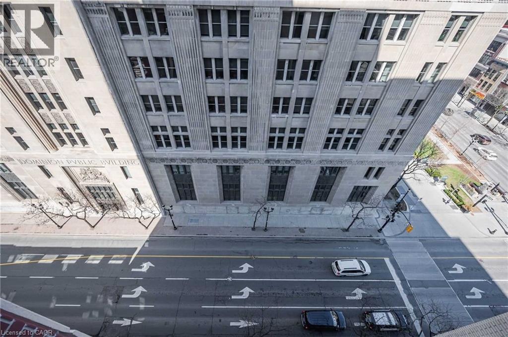 Urban streetscape featuring architectural buildings with multiple window arrays - 112 King Street E Unit# 907, Hamilton, ON