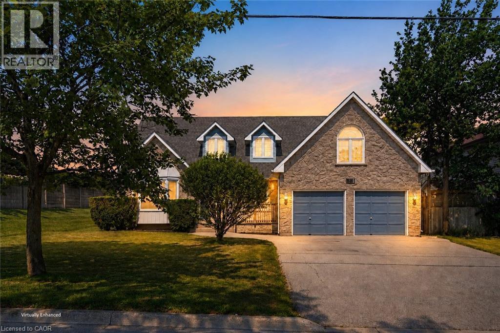 Stone veneer facade with a prominent two-car garage featuring blue garage doors - 381 Kerman Avenue, Grimsby, ON - Outdoor