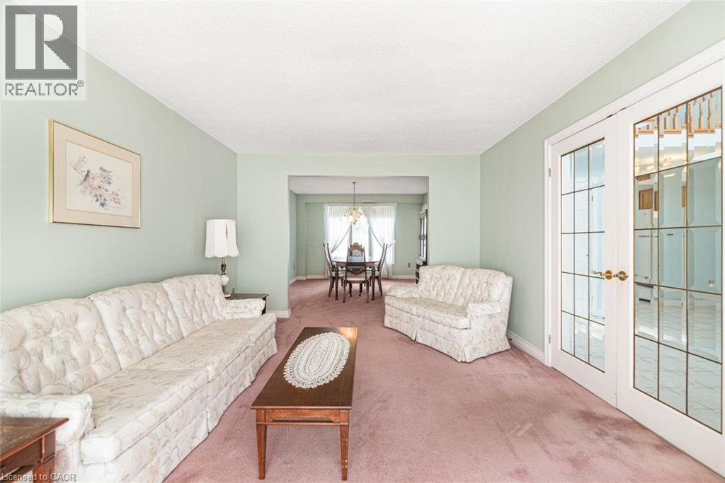 Living area with light green walls and pink carpeting - 381 Kerman Avenue, Grimsby, ON - Indoor Photo Showing Living Room