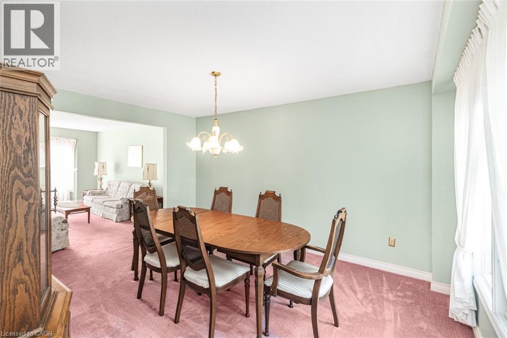 Dining area featuring light green walls, a gold-toned chandelier, and white baseboards - 381 Kerman Avenue, Grimsby, ON - Indoor Photo Showing Dining Room