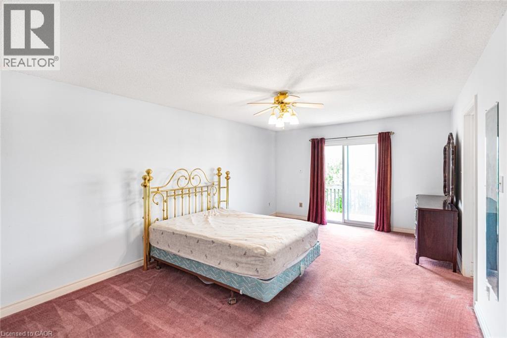 Room with white walls, red carpeting, a ceiling fan with integrated lighting, and a glass sliding door - 381 Kerman Avenue, Grimsby, ON - Indoor Photo Showing Bedroom