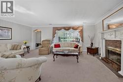 Living area featuring a white decorative mantel with an integrated fireplace and brick surround -