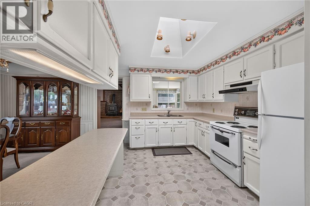Kitchen featuring white cabinetry, light-toned countertops, and hexagonal tile flooring - 114 E Second Road E, Stoney Creek, ON