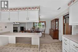 Kitchen featuring white cabinetry and a light-toned countertop, with a decorative floral border -