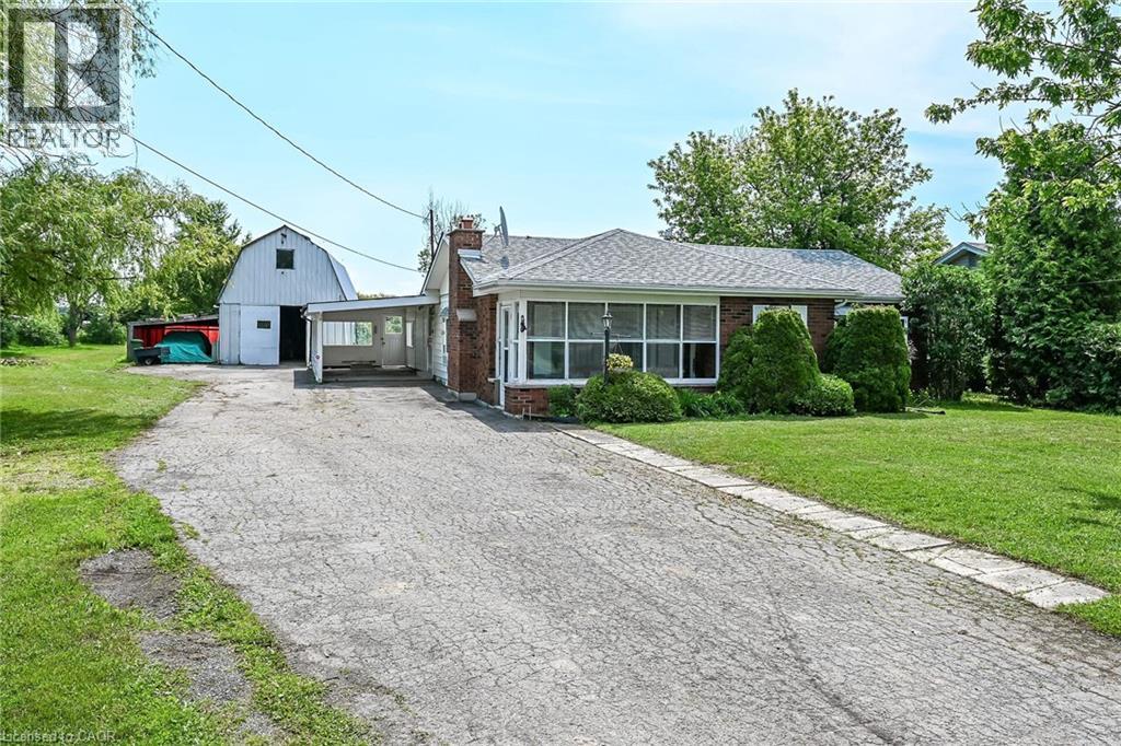 Brick exterior residence with an attached carport and a white gable barn - 114 E Second Road E, Stoney Creek, ON