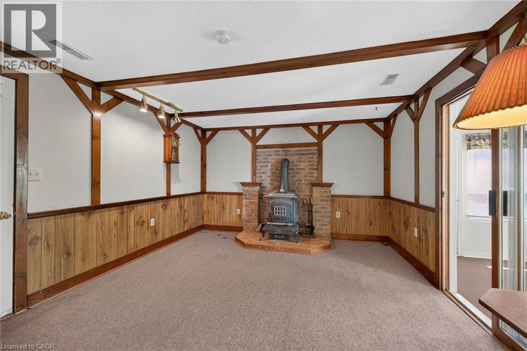Interior room featuring a brick wood-burning stove with a raised hearth - 114 E Second Road E, Stoney Creek, ON