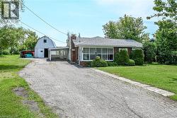 Brick exterior residence with an attached carport and a white gable barn -