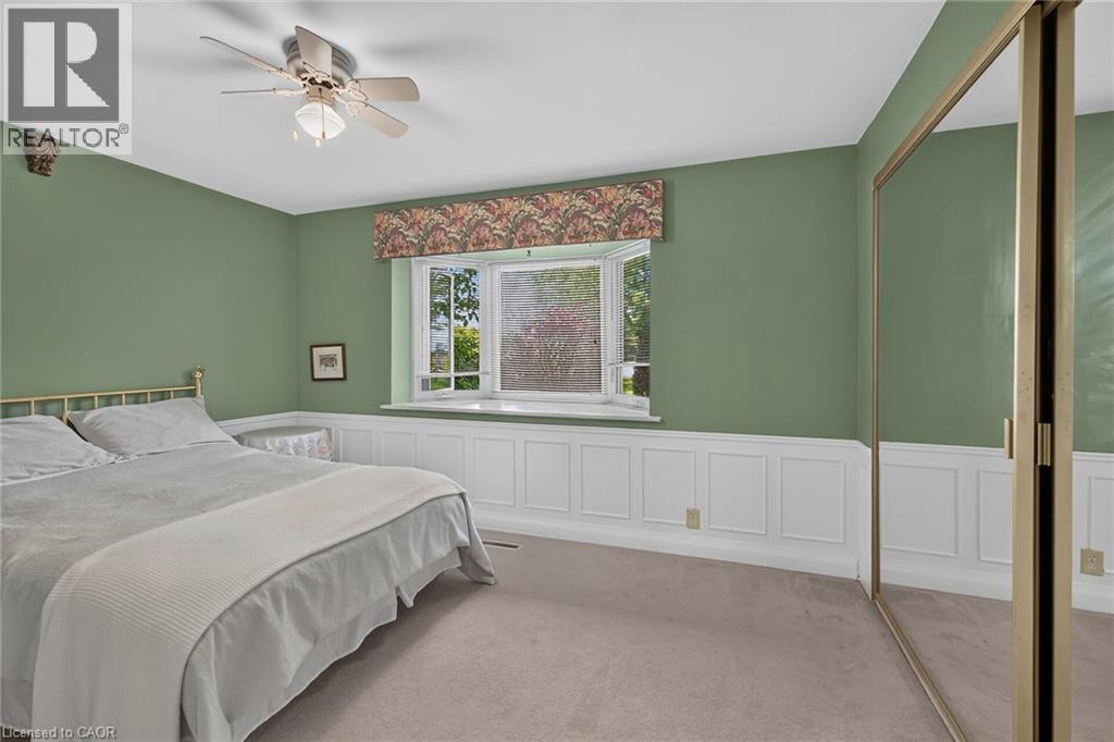 Room featuring a bay window with a valance, white wainscoting, and carpet flooring - 114 E Second Road E, Stoney Creek, ON