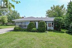 Brick exterior with a gabled roofline, a bay window, and a sunroom with multiple pane windows -
