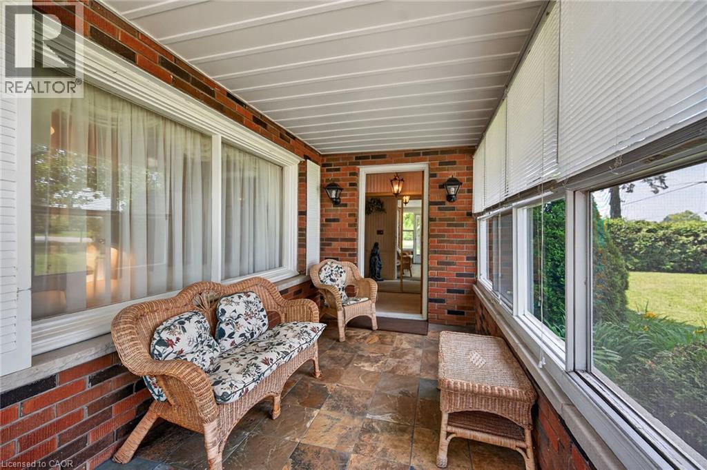Enclosed porch featuring brick walls and flagstone flooring - 114 E Second Road E, Stoney Creek, ON