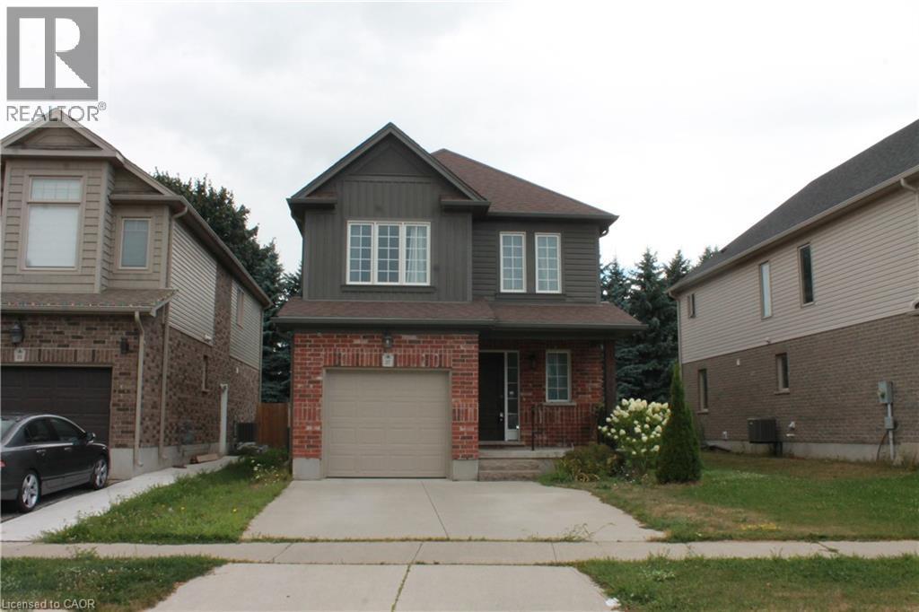 Two-story residence featuring a brick and siding facade, an attached garage, and a concrete driveway - 27 Stillwater Street, Kitchener, ON
